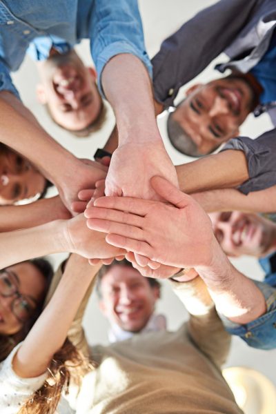 getting-it-done-through-teamwork-low-angle-shot-group-coworkers-stacking-their-hands-top-each-other